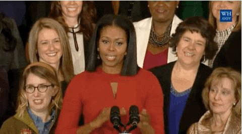 Michelle Obama making hand signal for money.