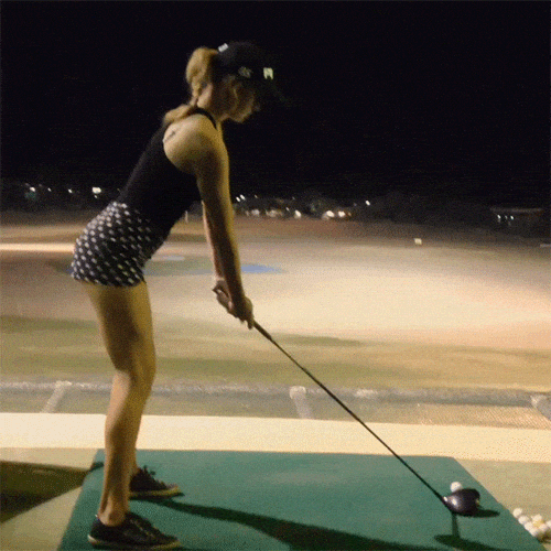 Woman hitting golf ball with right side bend 