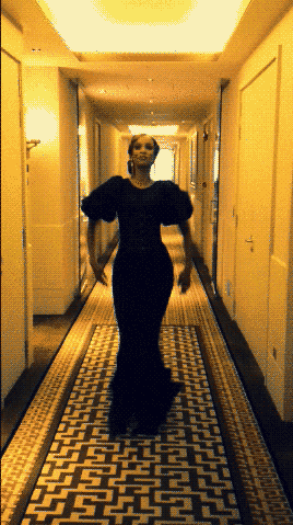 Woman wearing a fancy gown walking through the hotel corridor