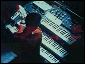 Overhead view of Ralf Hütter playing a bank of 70s synths and keyboards