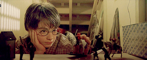 A young Harry Potter plays, seemingly bored