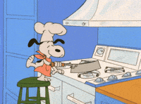 Snoopy wearing a chef's hat cooking at a stove