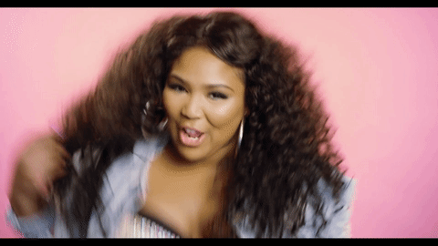 ENTITY presents gif of lizzo doing her hair toss and checking her nails.