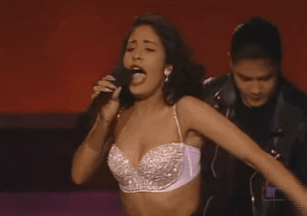 Selena performing in a sequined white bustier. 