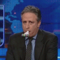 Photo of Jon Stewart depressedly blowing a party noisemaker