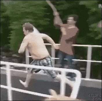 A man jumps from a high height into a pool.