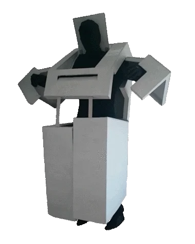 Figure moving inside a white boxy costume shaped like a machine