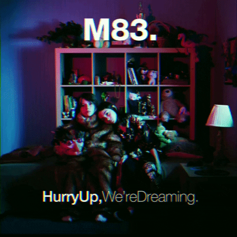 M83's Hurry Up, We're Dreaming album cover - two kids huddled on a sofa in a cluttered room