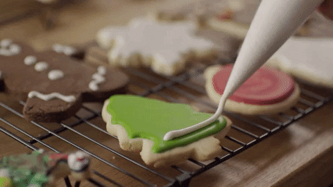 Decorating a Christmas tree cookie with icing