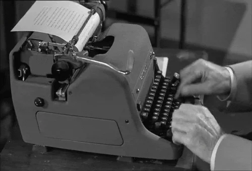 Hands typing on a vintage typewriter