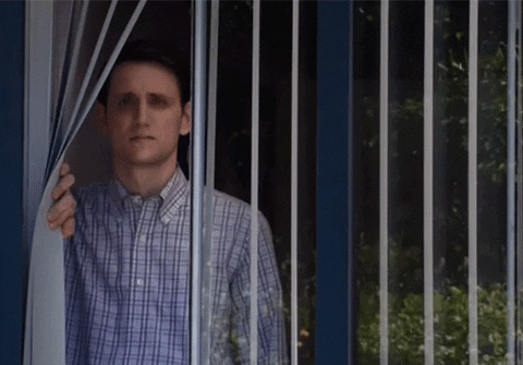 Gif of a man sadly looking through a window from his house. -- first year as a teacher