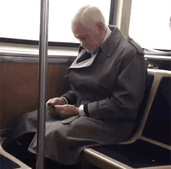 homem velho usando celular no trem