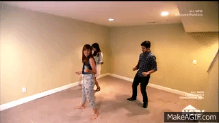 Three people dancing in an empty room.