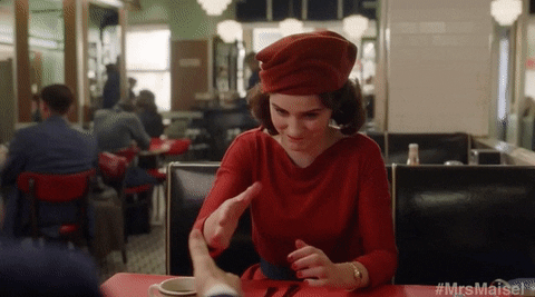 Chica vestida de rojo con un gorro estrechando la mano de un hombre en un restaurante