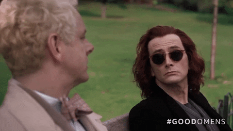 Aziraphale (Michael Sheen) and Crowley (David Tennant) from Good Omens facing each other on a park bench