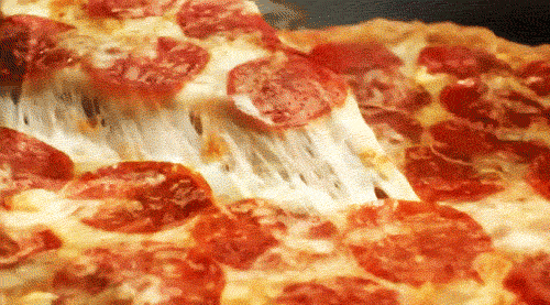 Een snee pepperoni pizza wordt omhoog getrokken waardoor de kaas meerekt.