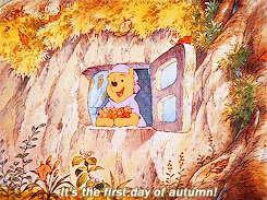 A GIF of Winnie the Pooh throwing leaves while saying "It's the first day of autumn!"