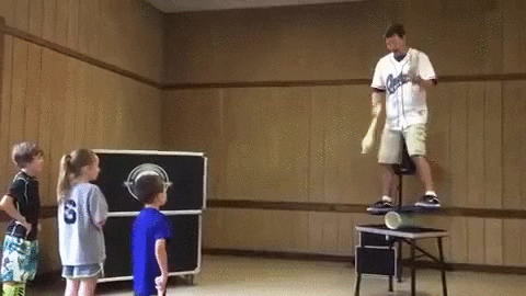 Gif of a man juggling bowling pins with a kid hitting him with another bowling pin.
