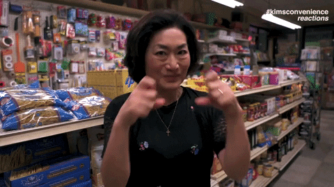 Woman in Kim's Convenience blowing a kiss.