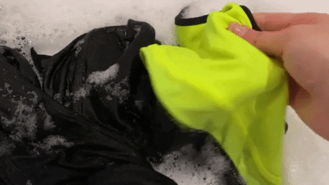Gif of gym clothes being hand washed in a basin