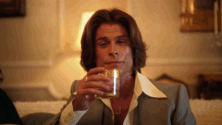 GIF of Rob Lowe sipping on a whisky from the movie "Behind the Candelabra"