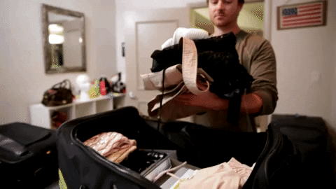 a man putting clothes in a luggage