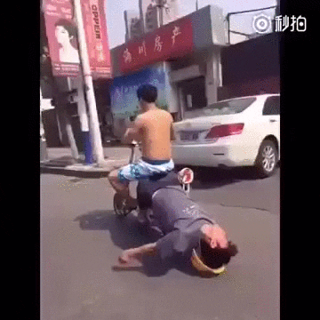 gif of drunk man leaning off back of scooter with head resting on hat
