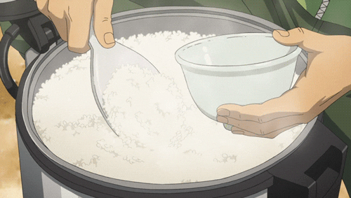 hands using a spoon to put rice from a steaming pot into a bowl