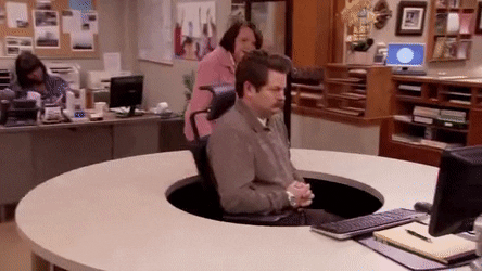 Office worker calmly spins around in chair to avoid talking to colleague who is trying to get his attention.