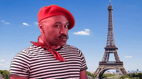 guy dressed as a french man standing in front of a green screen on the eiffel tower 