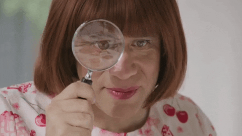 lady looking through magnifying glass gif