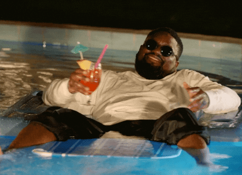 Man chilling on a pool float with a martini in his hand