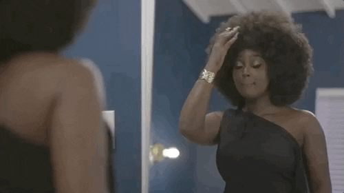 a GIF of a girl with 4c hair shaping her afro