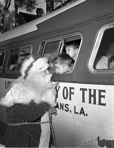 Santa "shhh"ing kids on Loyola of the South bus, 1950s/1960s