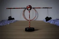 Small balance scale with a shoe hanging from each arm