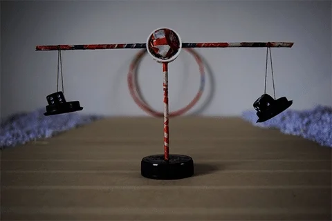 Small balance scale with a shoe hanging from each arm