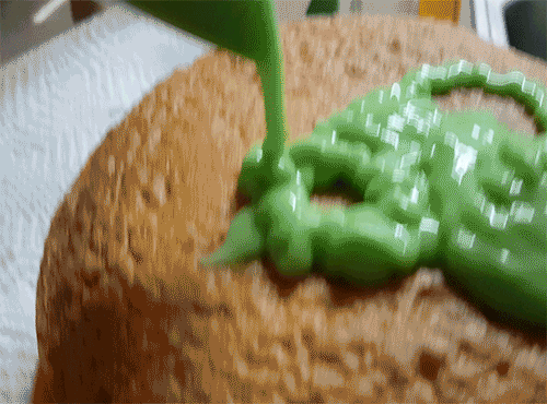 Decorating yellow birthday cake with slime pastry bag