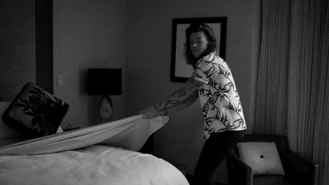 Harry Styles pulling sheets off of bed