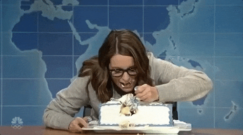 GIF of Tina Fey scarfing  down cake from saturday night live skit