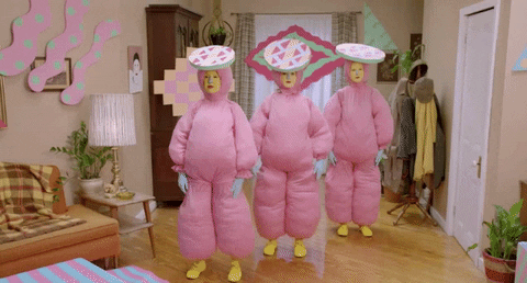 Three women in pink blow up suits exercising