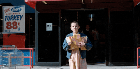 Eleven walking out of a store with boxes of Eggo waffles. 