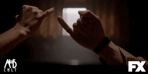 A GIF of two hands forming a pinky promise. 