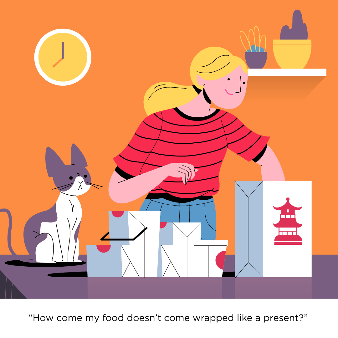 A woman is taking delivery food from one bad and putting it on the counter. A cat to her left is watching her.