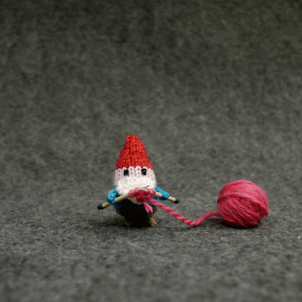 gif of tiny knitted gnome knitting hearts that float away