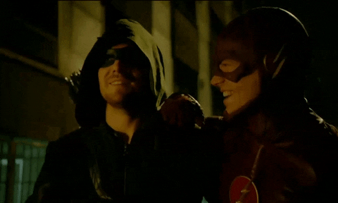 Green Arrow (Oliver Queen as played by Stephen Amell) and The Flash (Barry Allen as played by Grant Gustin) walking down the street leaning on each other