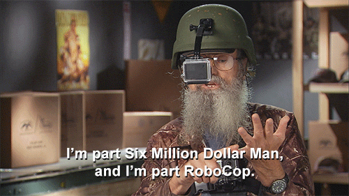 A middle close up GIF of a disheveled man with elaborate makeshift tech gear equipped on his chest and helmet. He is saying: "I'm part Six Million Dollar Man, and I'm part RoboCop."