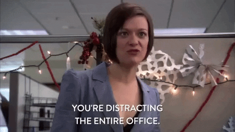 Vrouw in een paars pak in een kantoor met kerstversieringen zegt 