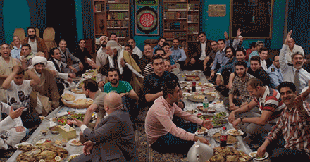 An Arab Muslim community having dinner at a mosque rejoice.