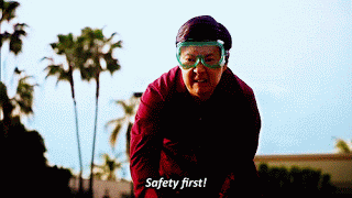 Safety first! Animated GIF of person wearing safety goggles pointing to goggle and saying 'safety first'