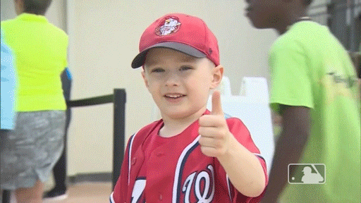 Young baseball fans giving a thumbs up